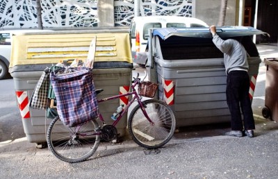 A man searches through trash bins in Girona, Spain. Across Spain, people are increasingly dumpster diving for scraps of food or metal. (Courtesy of Richard van der AA/Demotix/Corbis)