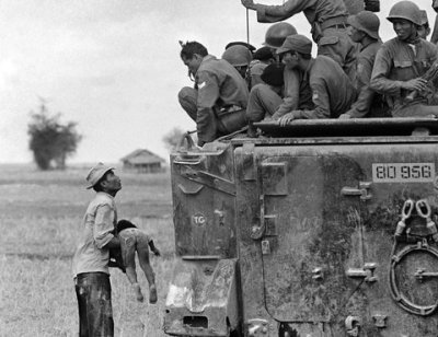 Horst Faas/Associated Press A farmer helplessly holds the body of his dead child as South Vietnamese troops look on, March 19, 1964. The child was killed as government forces pursued guerrillas into a village near the Cambodian border.