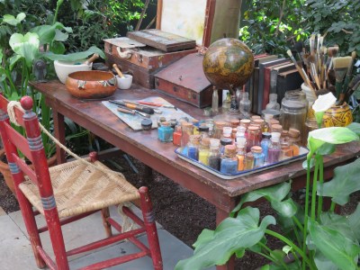 A reimagine corner from Frida's studio features her desk, brushes and paint pots.